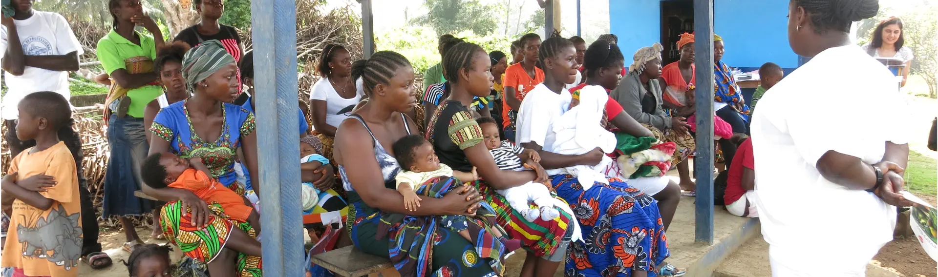 Mothers and caregivers gathered with children at a community health session in Africa